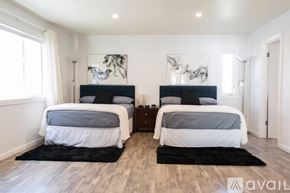 Huntington Beach condo for rent - A bedroom with two beds and a rug on the floor.