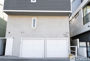 Huntington Beach condo for rent - A two-story building with a garage door on the bottom floor.