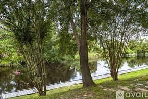 Gulfport apartment for rent - A serene park with a pond, trees, and a wooden walkway.