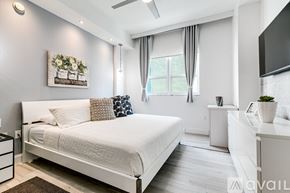 Miami apartment for rent - A bedroom with a large bed and a television on the wall.