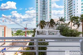 Miami apartment for rent - A view from a balcony overlooking a construction site with cranes and buildings in the background.