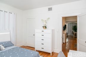 Miami apartment for rent - A bedroom with a bed, dresser, and a window with curtains.