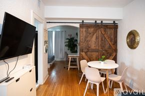 Miami apartment for rent - A room with a white table and chairs, a flat screen TV, and a wooden door.