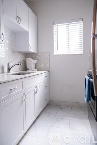 Miami apartment for rent - A white kitchen with a sink and a window.