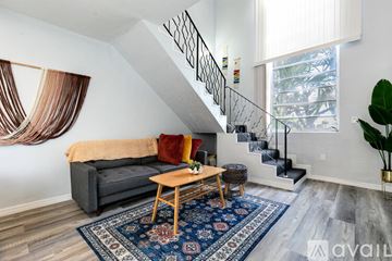 Virginia Gardens apartment for rent - A living room with a grey couch, a wooden coffee table, and a rug.