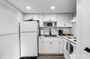 Virginia Gardens apartment for rent - A kitchen with white appliances and cabinets.