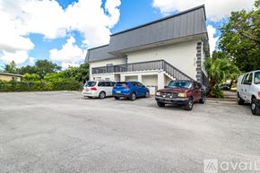 Virginia Gardens apartment for rent - A parking lot with cars and a building in the background.