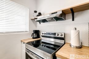 Virginia Gardens apartment for rent - A modern kitchen with a stove top oven and a wooden counter.