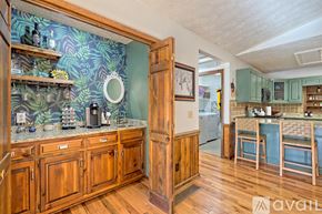 Clayton house for rent - A kitchen with wooden cabinets and a green backsplash.