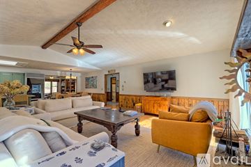 Clayton house for rent - A living room with a yellow couch and a wooden coffee table.