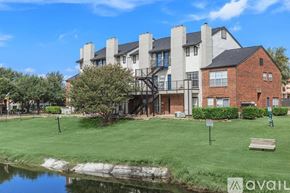 Plano apartment for rent - A large building with a grassy area in front and a body of water in the foreground.