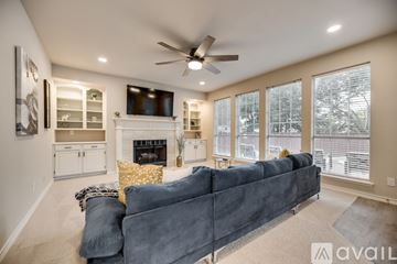 Plano apartment for rent - A living room with a grey couch and a fireplace.