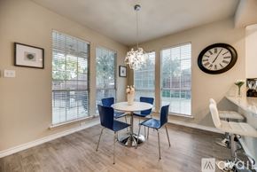 Plano apartment for rent - A dining room with a table set for four and a chandelier hanging from the ceiling.