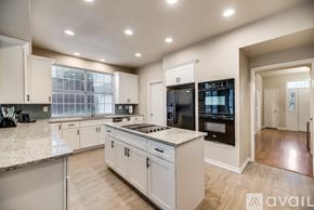 Plano apartment for rent - A modern kitchen with white cabinets and a large island.
