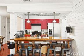 Mckinney house for rent - A kitchen with red cabinets and a wooden table.