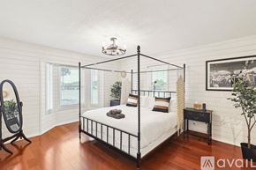 Mckinney house for rent - A bedroom with a four-poster bed and a wooden floor.