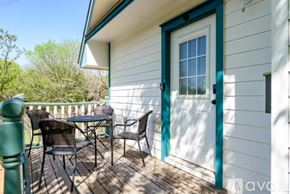 San Marcos apartment for rent - A white house with a green door and a deck with a table and chairs.