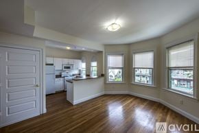 Boston apartment for rent - A kitchen with a white door and a window with a view of houses.