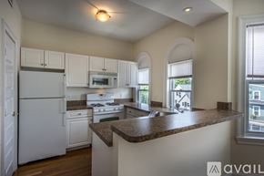 Boston apartment for rent - A kitchen with white appliances and a brown countertop.