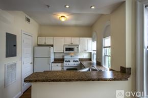 Boston apartment for rent - A kitchen with white appliances and a granite countertop.