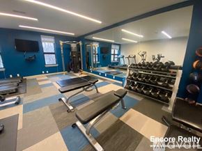 Brookline apartment for rent - A gym with a variety of equipment including a bench press, a squat rack, and a treadmill.