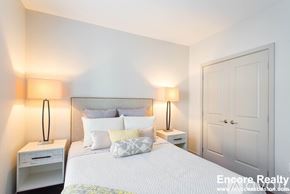 Brookline apartment for rent - A bedroom with a bed, nightstands, and a door.