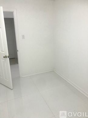 Oakland Park house for rent - A white room with a door and a light switch on the wall.