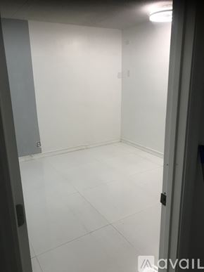 Oakland Park house for rent - A white tiled room with a door on the right.