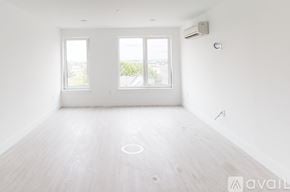 Boston apartment for rent - A spacious room with a large window and a wooden floor.