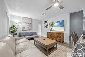 Fort Lauderdale apartment for rent - A living room with a white couch and a painting of a beach scene on the wall.