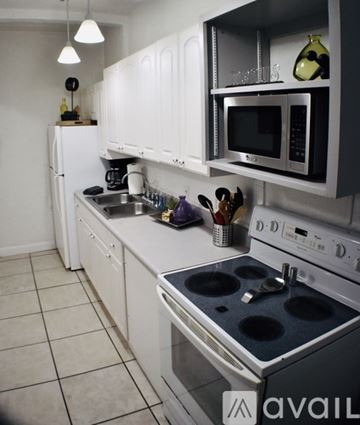 Tampa apartment for rent - A kitchen with white cabinets and a black stove top.