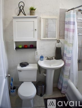 Tampa apartment for rent - A small white bathroom with a toilet, sink, and a cabinet above it.