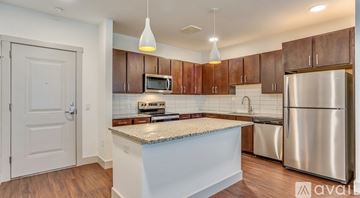Lewisville apartment for rent - A kitchen with a stainless steel refrigerator and wooden cabinets.