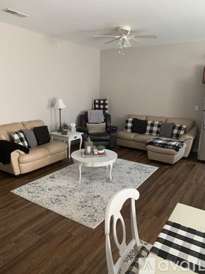 Cincinnati apartment for rent - A living room with a beige couch, a white coffee table, and a white chair.