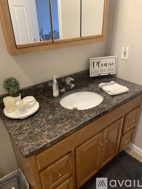 Cincinnati apartment for rent - A bathroom sink with a sign that says "Please wash your hands.".