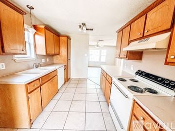 Lubbock house for rent - A kitchen with wooden cabinets and white appliances.