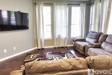 Irving apartment for rent - A living room with a large couch and a flat screen TV mounted on the wall.