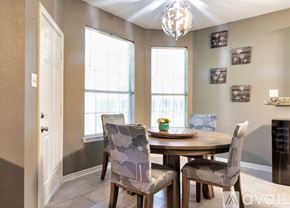 Irving apartment for rent - A dining room with a table set for two and a chandelier hanging from the ceiling.