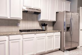 Irving apartment for rent - A kitchen with white cabinets and a stainless steel refrigerator.