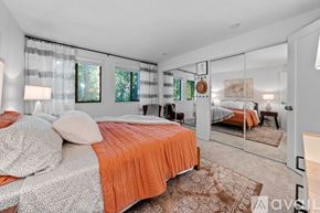 Bainbridge Island apartment for rent - A bedroom with a bed covered in an orange and grey bedspread.