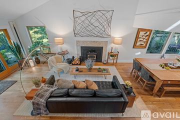 Bainbridge Island apartment for rent - A living room with a black couch and a fireplace.