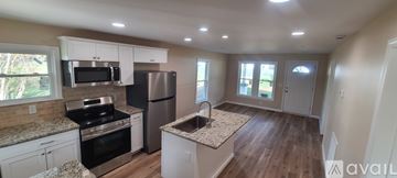Valdese apartment for rent - A kitchen with white cabinets and a granite countertop.