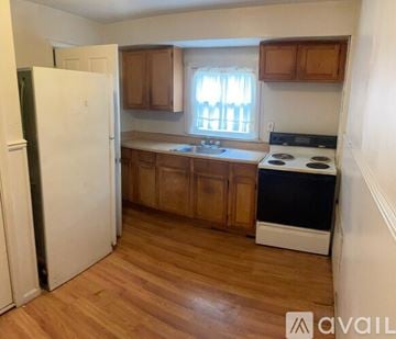 Detroit house for rent - A kitchen with wooden cabinets and a white fridge.
