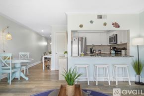 St. Pete Beach apartment for rent - A kitchen with white cabinets and a white table with chairs.