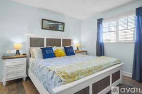 St. Pete Beach apartment for rent - A bedroom with a bed, nightstands, and a window.