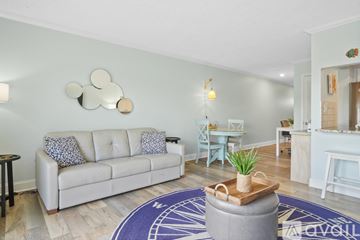 St. Pete Beach apartment for rent - A living room with a white couch and a round rug.
