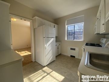 Brookline apartment for rent - A kitchen with white appliances and a window.