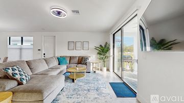 Fort Myers house for rent - A living room with a grey couch and a blue rug.
