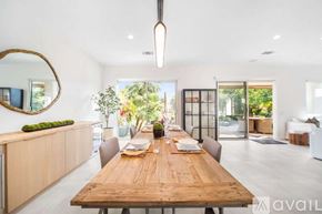 La Quinta house for rent - A modern dining room with a wooden table and chairs.