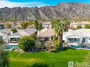 La Quinta house for rent - A large house with a pool in front of a mountain.